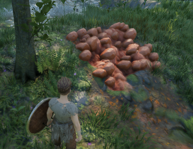 An ingame screenshot showing a mineable clay deposit. It is reddish-brown and lumpy.